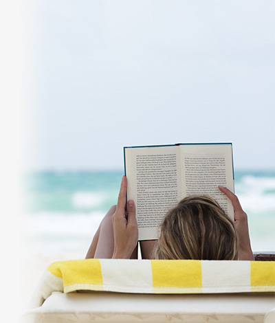 Woman reading a book on the beach